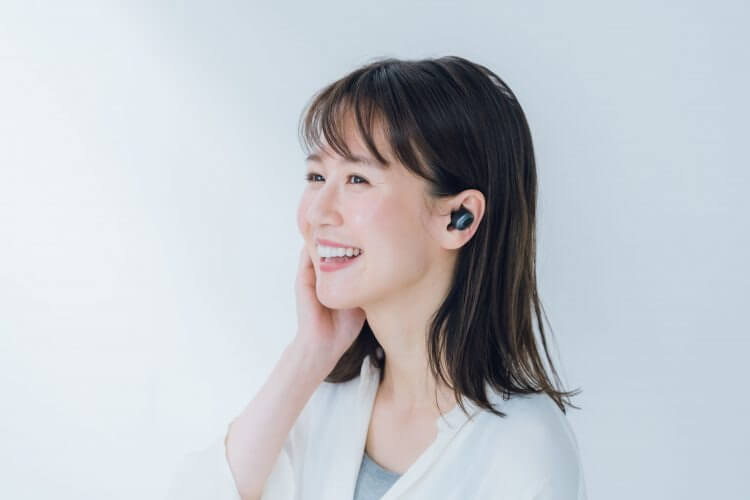ワイヤレスイヤホンで音楽を聴く女性