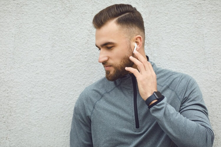 ワイヤレスイヤホンで音楽を聴く男性