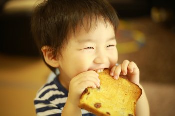 オーブンとトースターで焼いたパンを食べる子ども