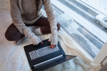 ハンドウォーマーを付けてパソコンを操作する女性