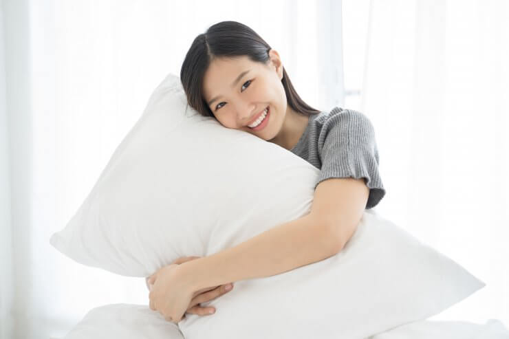 抱き枕を抱える女性のイメージ