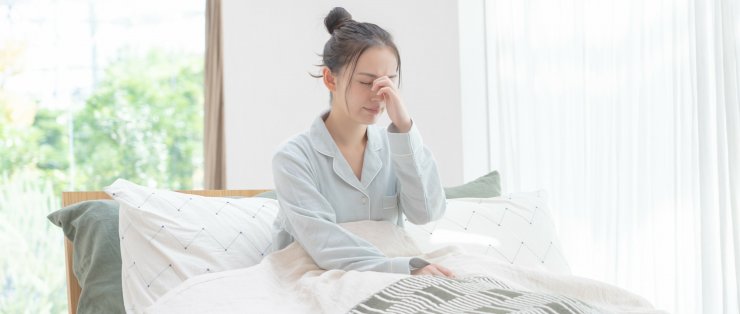 鼻を押さえる女性